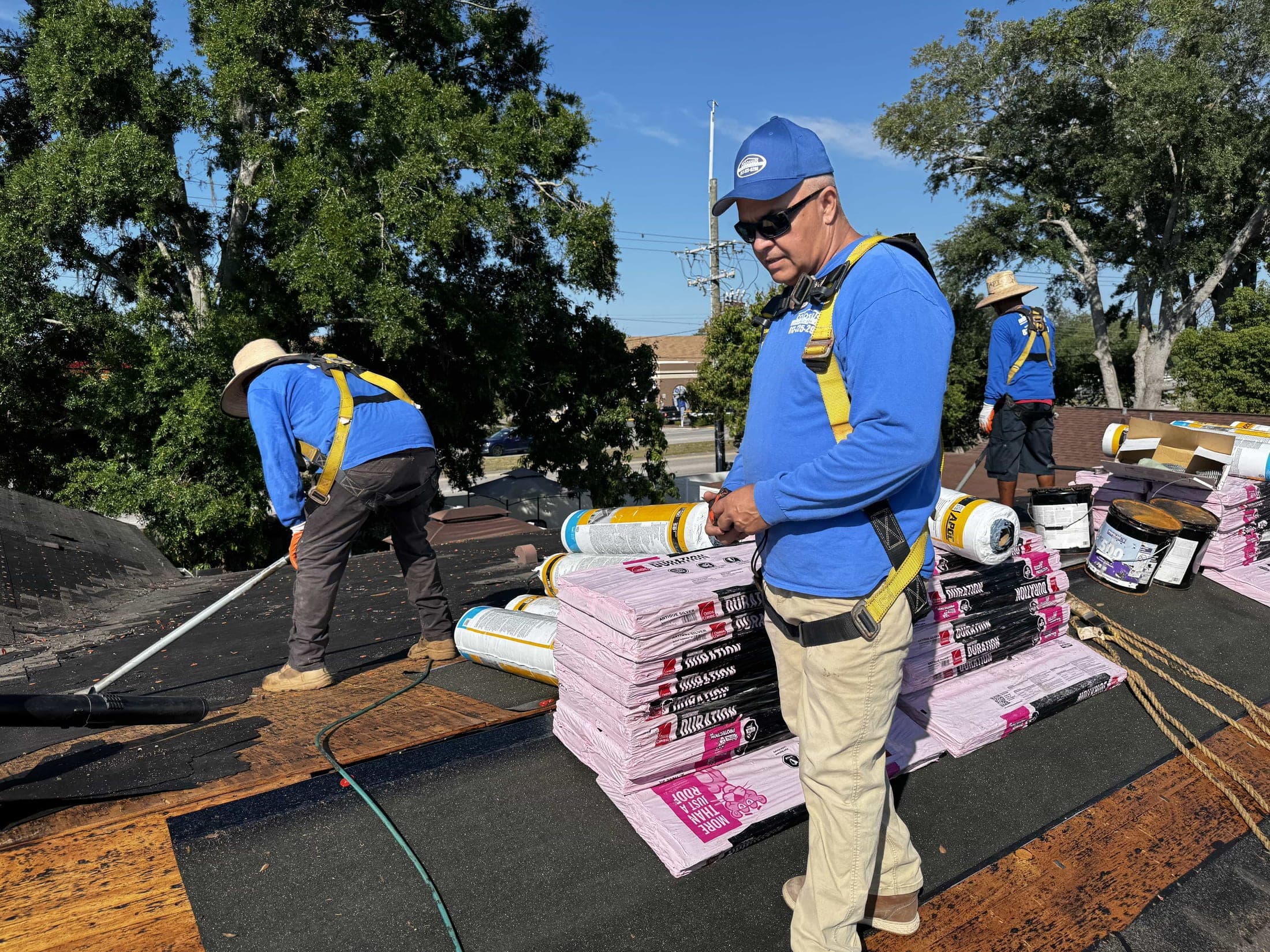 Crew member handling bundles of architectural shingles