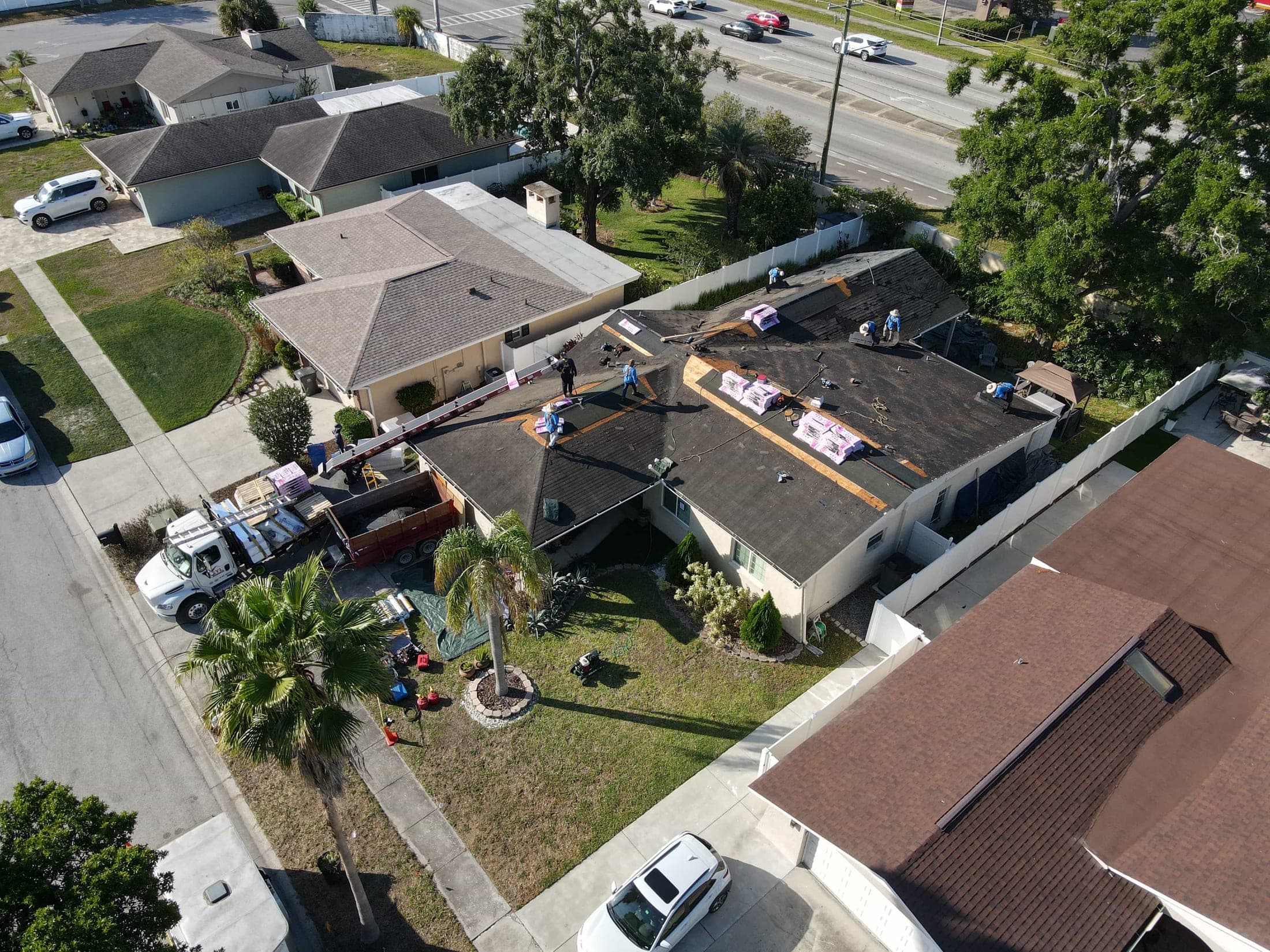 Aerial view of a roofing job site with materials staged